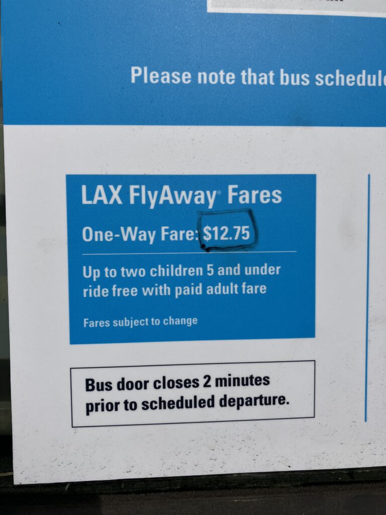 FlyAwayバスの片道料金$12.75が表示されたLAX空港の公式料金案内看板。5歳以下の子ども2名まで無料などの注意事項が記載されている。