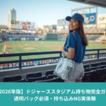 透明バッグを持ってドジャーススタジアムの客席に立つ女性。青い服装で、スタジアム内からグラウンドを見渡している様子。