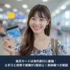 空港で楽天カードを手に微笑む日本人女性。海外旅行で楽天カードを利用するイメージの写真。