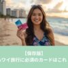ハワイのビーチを背景に楽天カードとJCBカードを持つ女性