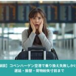 コペンハーゲン空港で乗り換えに間に合わずショックを受けるアジア人女性。空港ターミナルでスーツケースを前に立ち尽くしている様子。