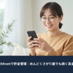 スマートフォンを見ながら笑顔で貯金残高を確認する主婦。自宅のリビングで、Wealthfrontを使ったシンプルなお金管理のイメージ。