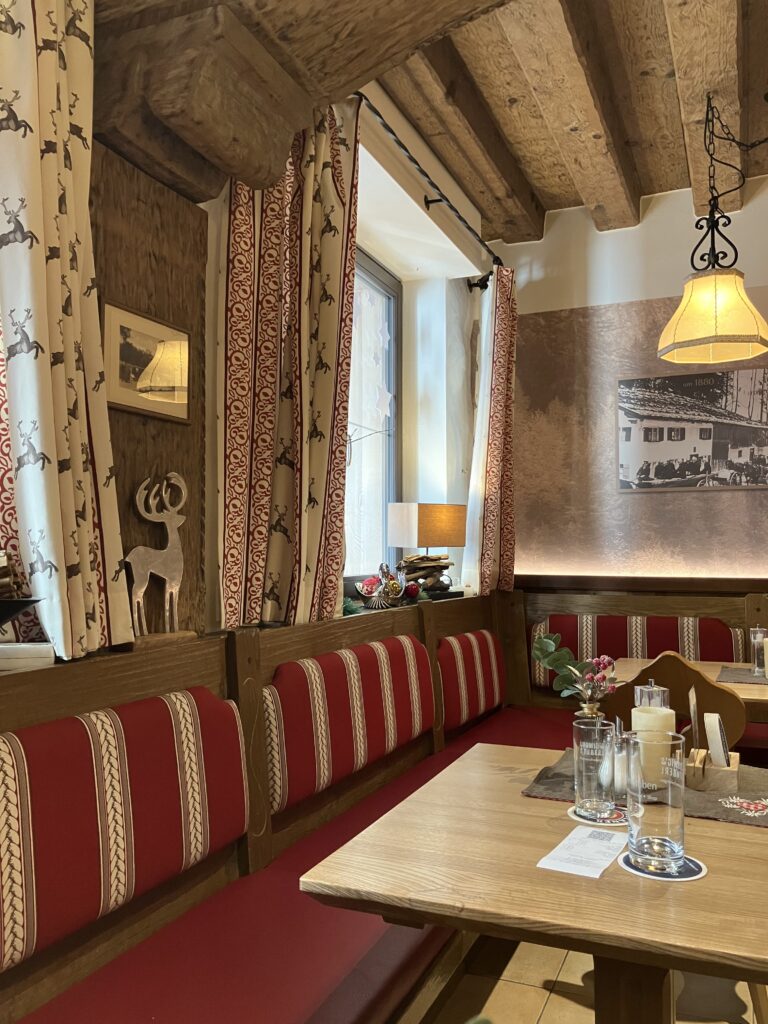 Paulanerレストランの店内。木の梁と赤いベンチが特徴的なドイツらしい空間