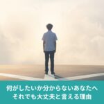 分かれ道の前で立ち止まり、進む方向に迷っている人物の後ろ姿